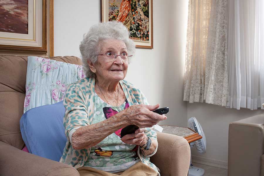 elderly-woman-home Elderly woman watches the TV in her home